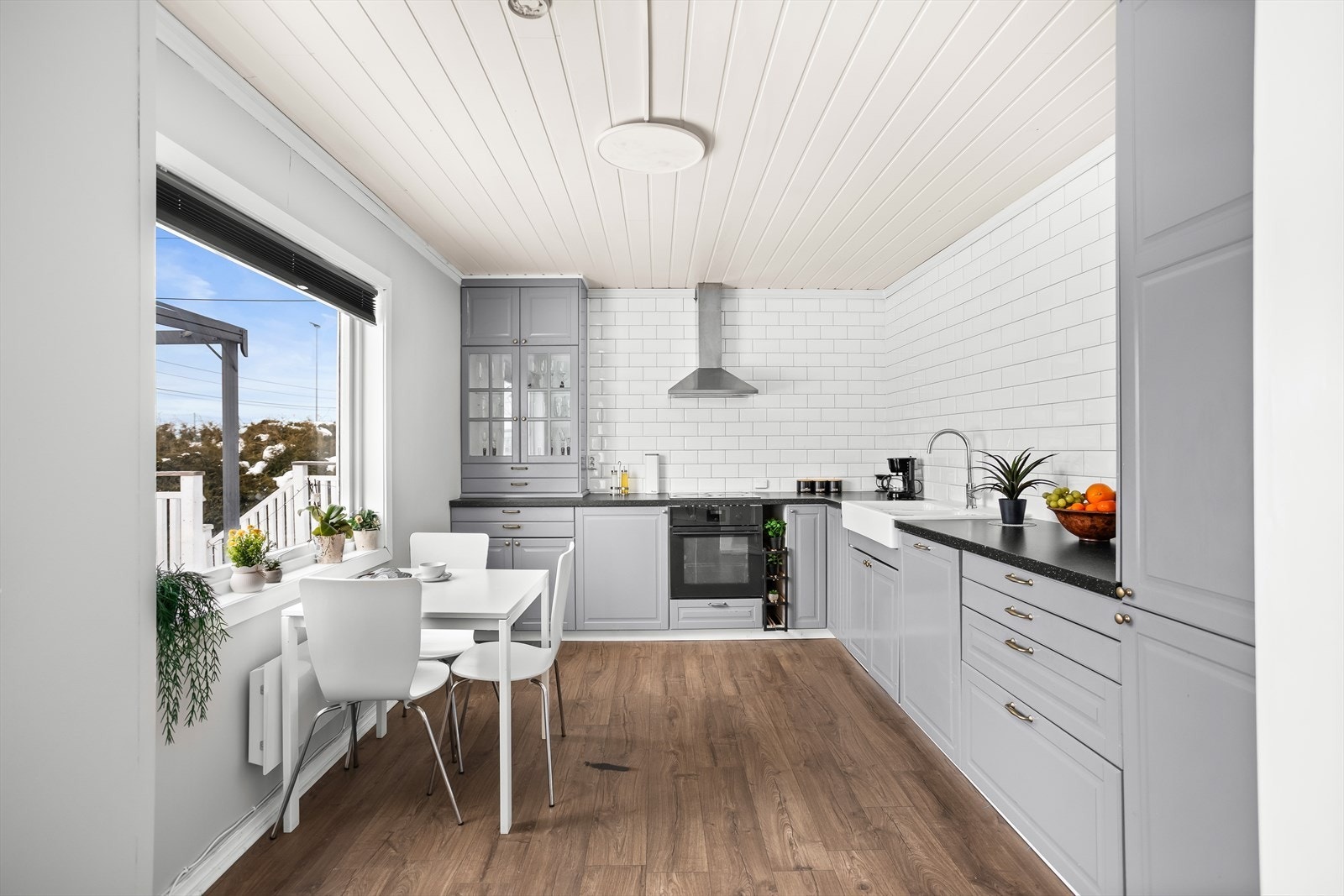 Kjøkkenet har en praktisk innredning med gode arbeidsflater og spiseplass ved vinduet. Galleribilde