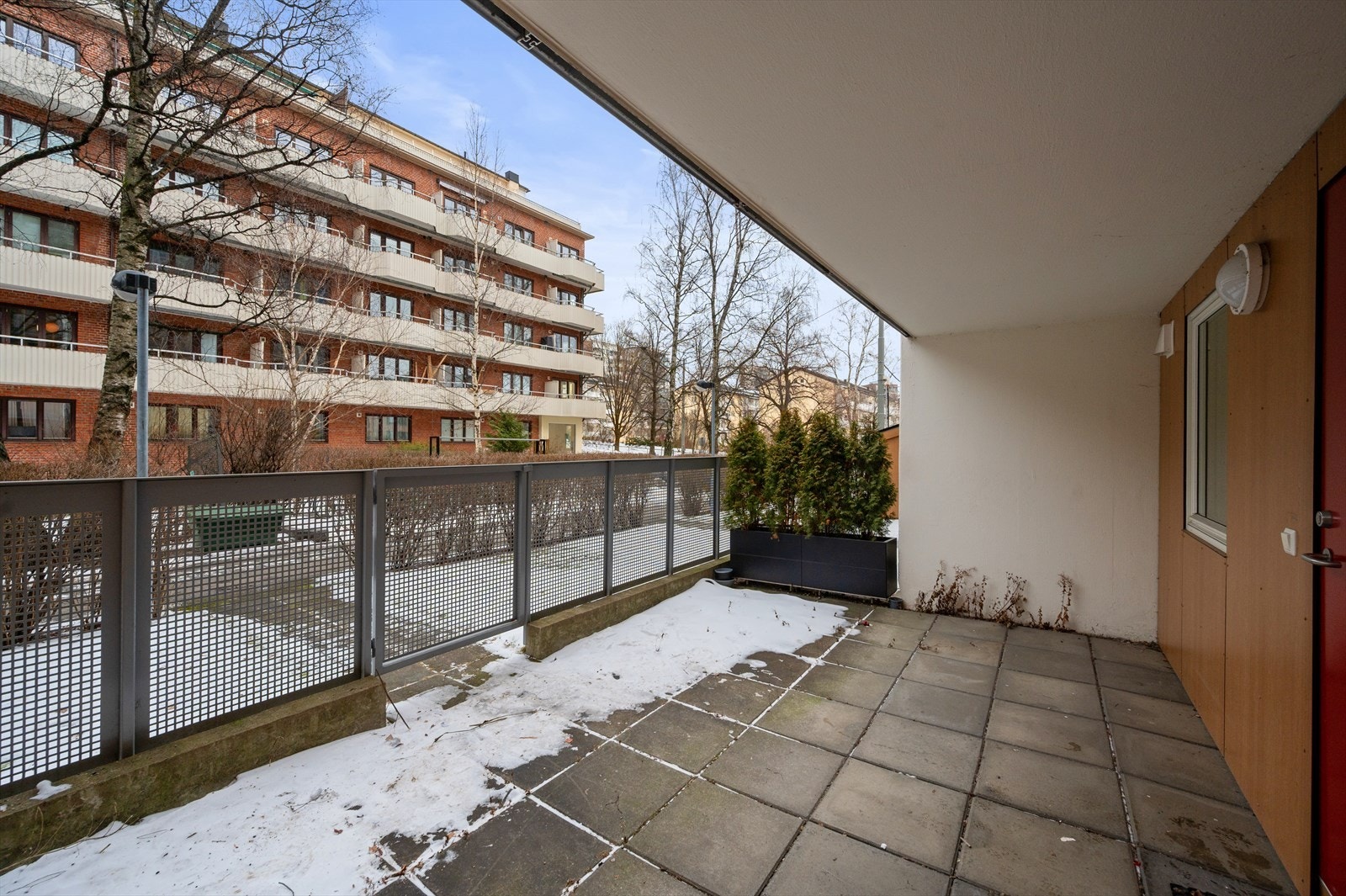 Uteområde med betongheller og gjerde mot gangvei - her kan det etableres en hyggelig uteplass. Galleribilde