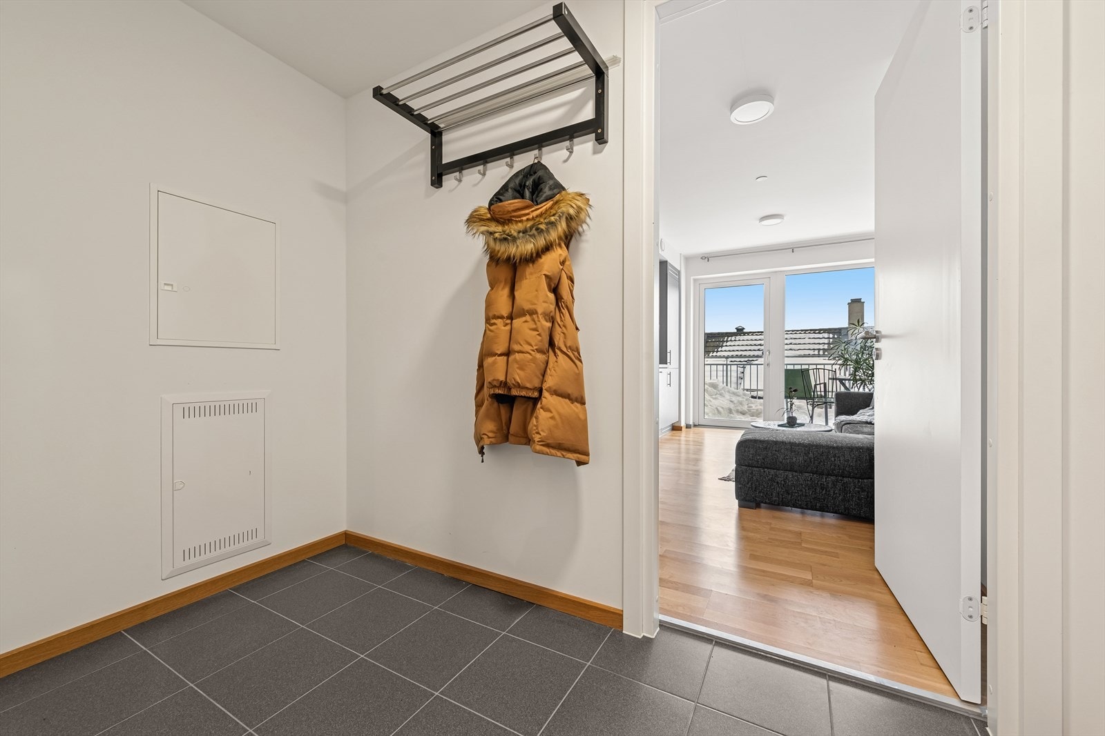 En innbydende entré med flislagt gulv ønsker deg velkommen inn. Her har du god plass til å henge fra deg yttertøy og sette fra deg fottøy på en praktisk og ryddig måte. Galleribilde