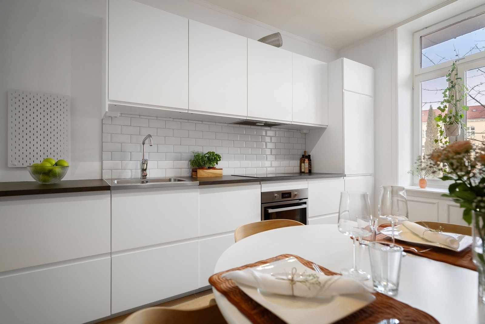 Det er integrerte hvitevarer som oppvaskmaskin, kjøleskap med fryser, stekeovn og platetopp (2025) med ventilator i overskapet. Galleribilde