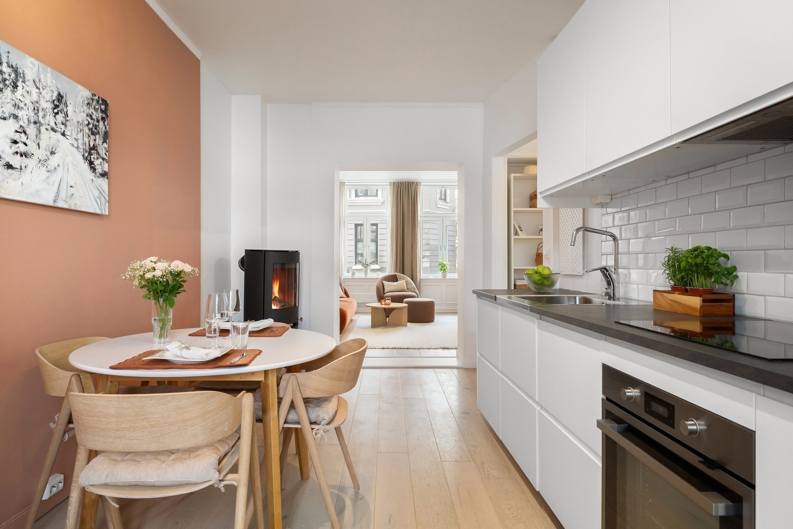 Veggene er malt i hvitt med en moderne kontrastvegg og samme en-stavs parkett belagt på gulv Galleribilde