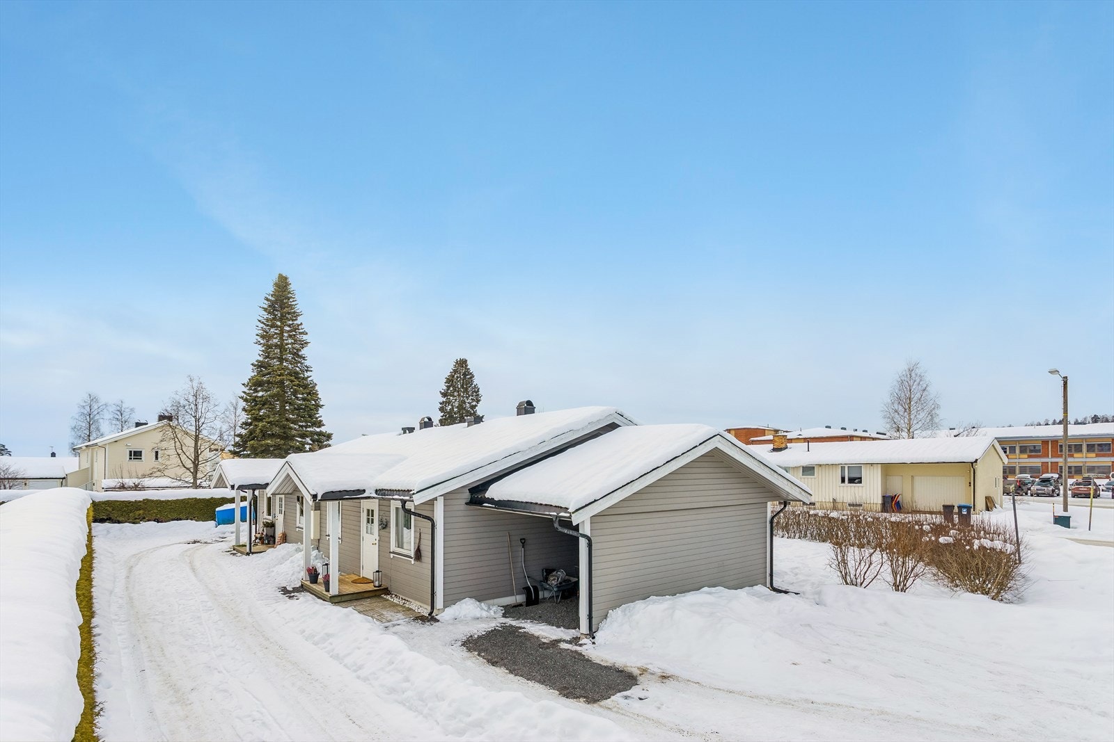 Boligen har en inntilbygget carport med tilhørende utvendig bod for praktisk oppbevaring. Galleribilde