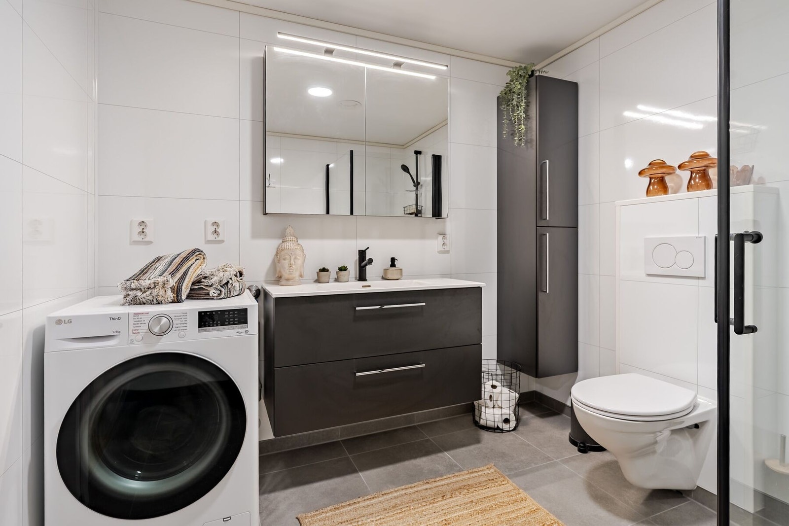 Badet er utstyrt med baderomsinnredning, dusjplass, toalett og opplegg for vaskemaskin Galleribilde