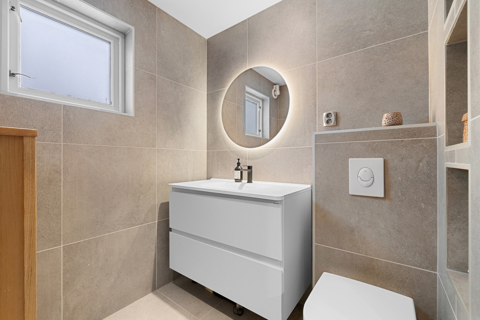 Pen og enkel innredning med god lagringsplass, dekorativt speil og integrert belysning. Galleribilde