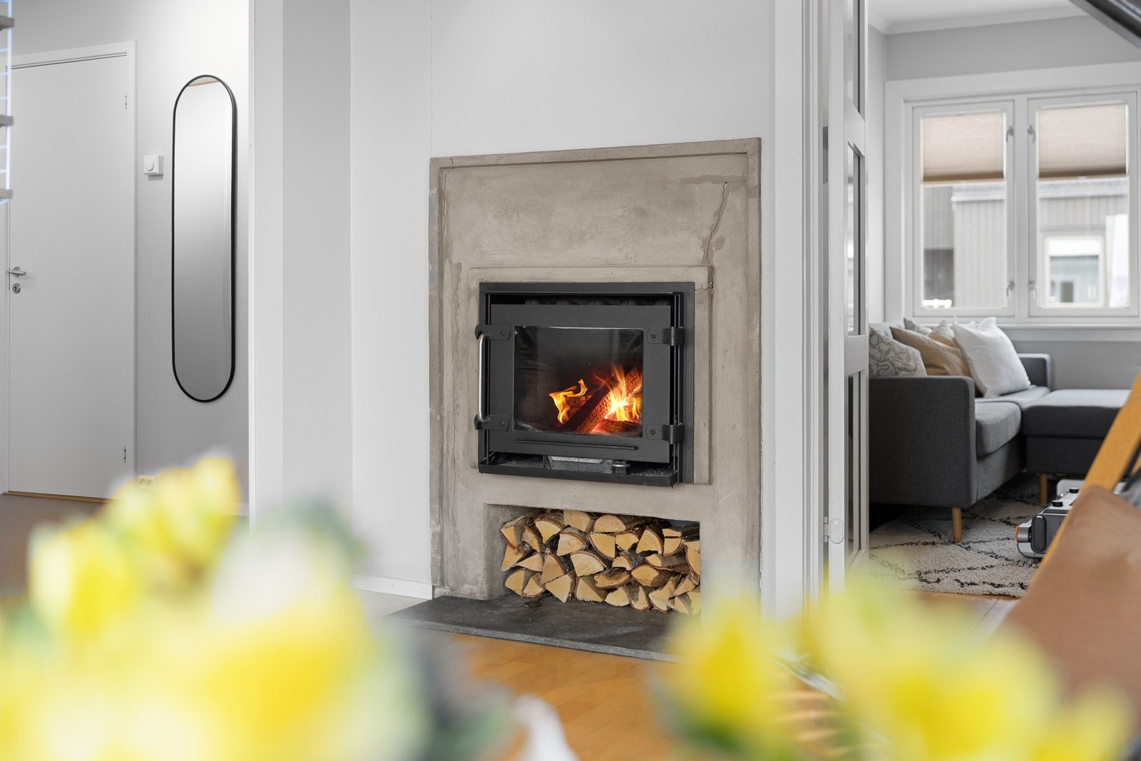 Den integrerte peisen med praktisk vedhylle gir lun varme og skaper en hyggelig atmosfære i rommet. Galleribilde