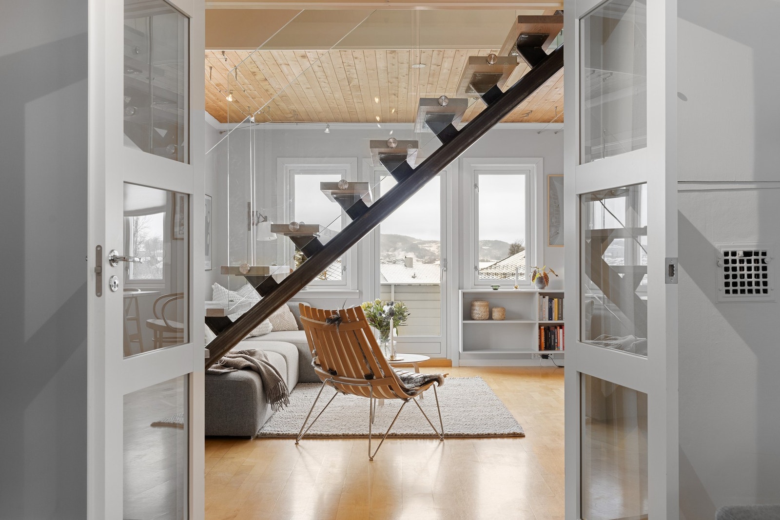 De dekorative dobbeldørene lar deg skjerme TV-stuen ved behov - perfekt for filmkvelder eller arbeidsro på hjemmekontor. Galleribilde