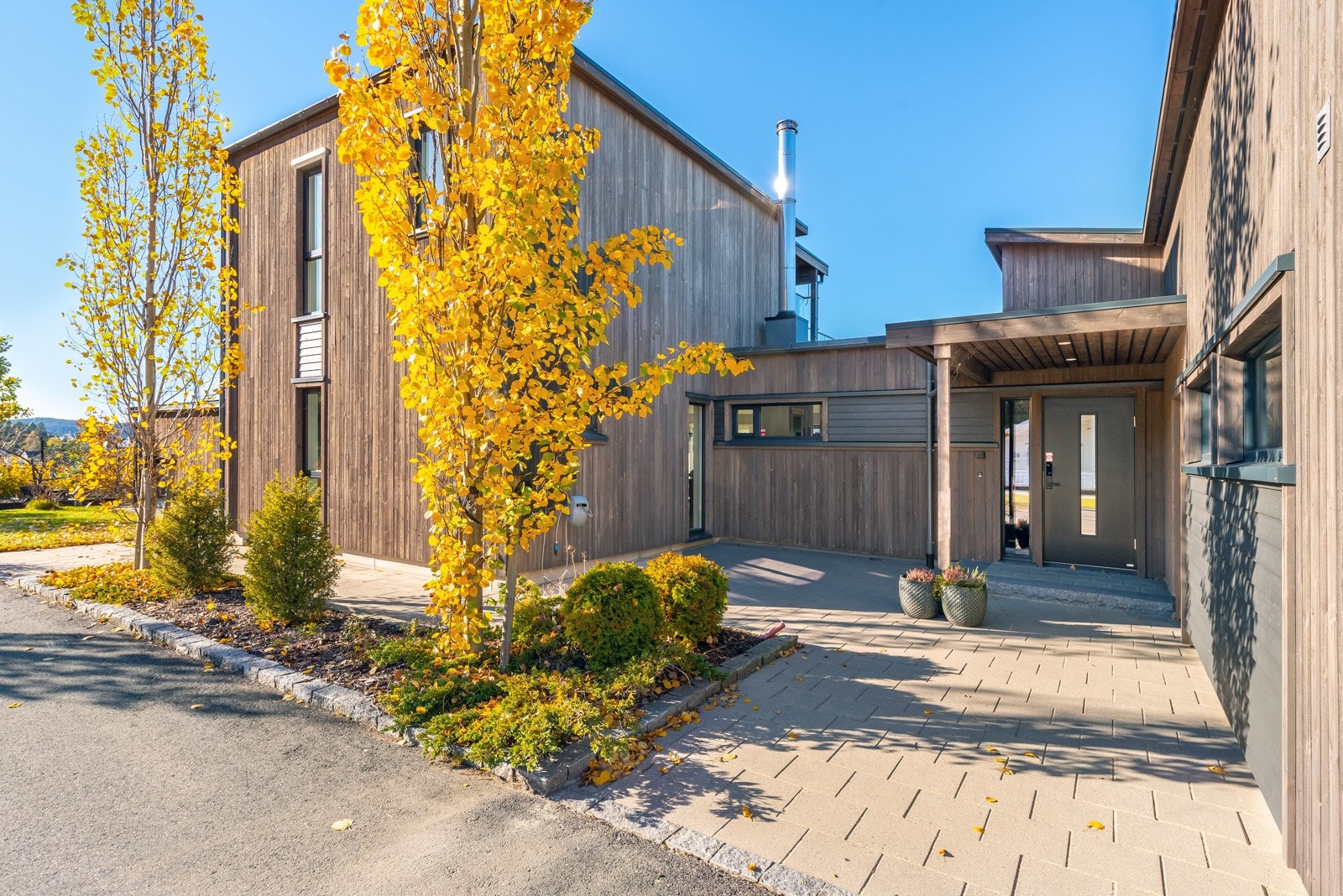 Lettstelt og innbydende tun med overbygget inngangsparti. Prydbusker og beplantning i bed setter prikken over i`en og blir en hyggelig velkomst. Galleribilde