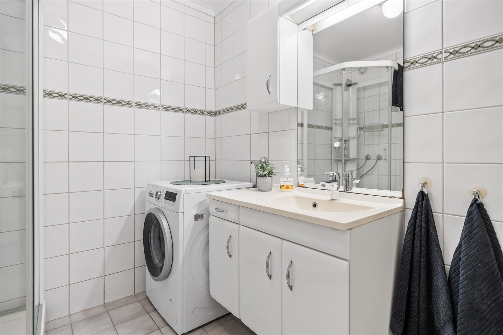 Veggene er helfliset i tidløse og slitesterke flater som både gir et stilrent uttrykk og er enkle å vedlikeholde. Over dette finner vi et malt, slett tak som gir rommet et rent og ryddig preg. Galleribilde