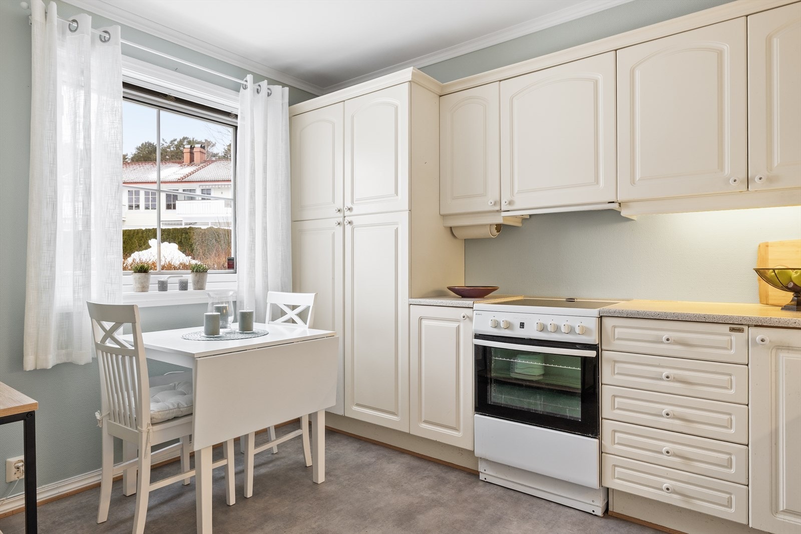 Den lyse utformingen bidrar til en luftig og harmonisk atmosfære, og kjøkkenet oppleves som et naturlig samlingspunkt i boligen. Foran kjøkkenvinduet er det avsatt plass til en hyggelig spiseplass - et perfekt sted med utsyn mot uteområdet. Galleribilde