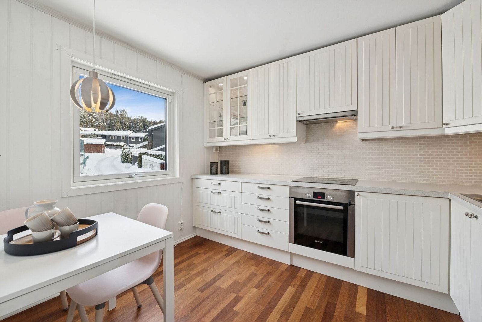 Lyst og tidløst kjøkken med god skapplass og hyggelig spiseplass ved vinduet. Galleribilde