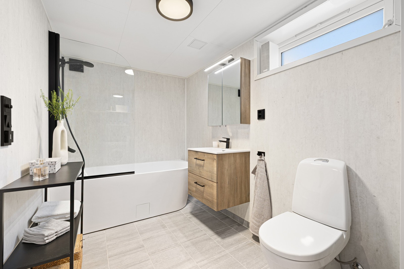 Lekkert og flislagt bad i kjelleren på romslige 8 kvm. Varmekabler i gulv og godt med lagringsplass i moderne innredning. Galleribilde