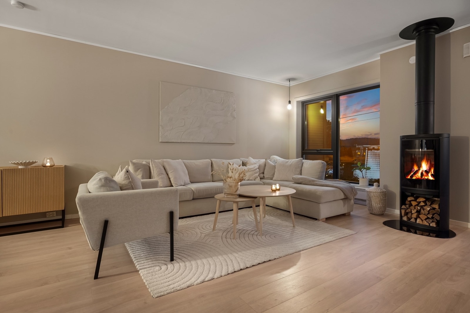 Den åpne løsningen gjør at man kan nyte både peisvarmen og utsikten fra hele oppholdsrommet. Galleribilde