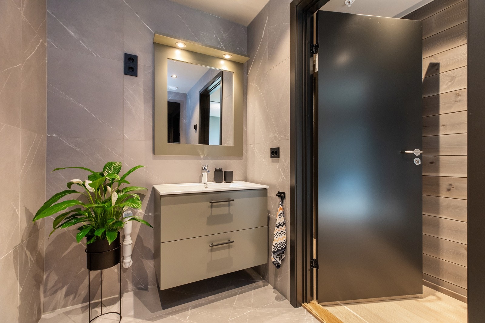 Flott bad med store kvadratiske fliser på gulv og vegg Galleribilde