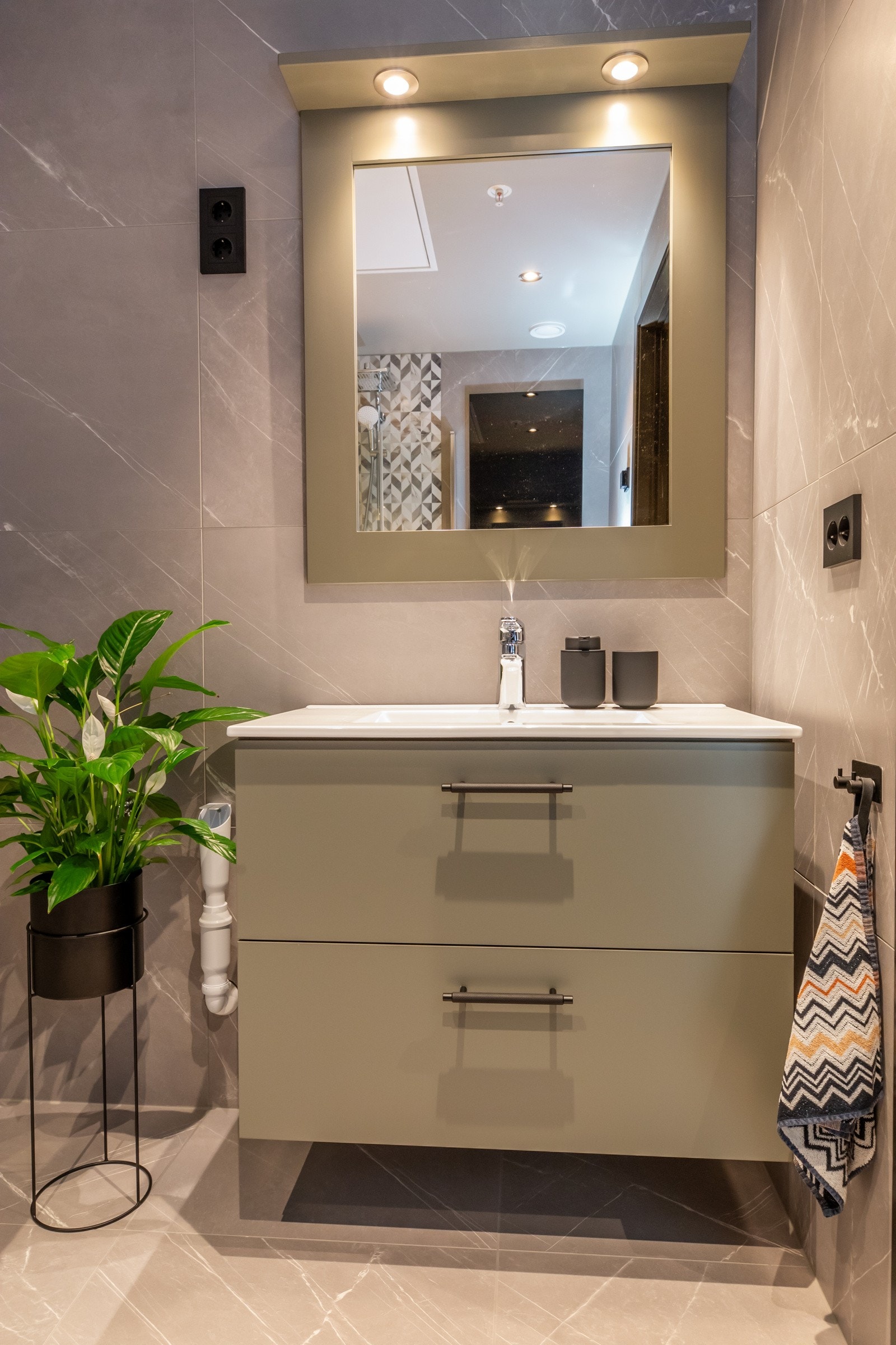 Innredning med nedfelt servant i skuffeseksjon og speil med ramme og spotter Galleribilde