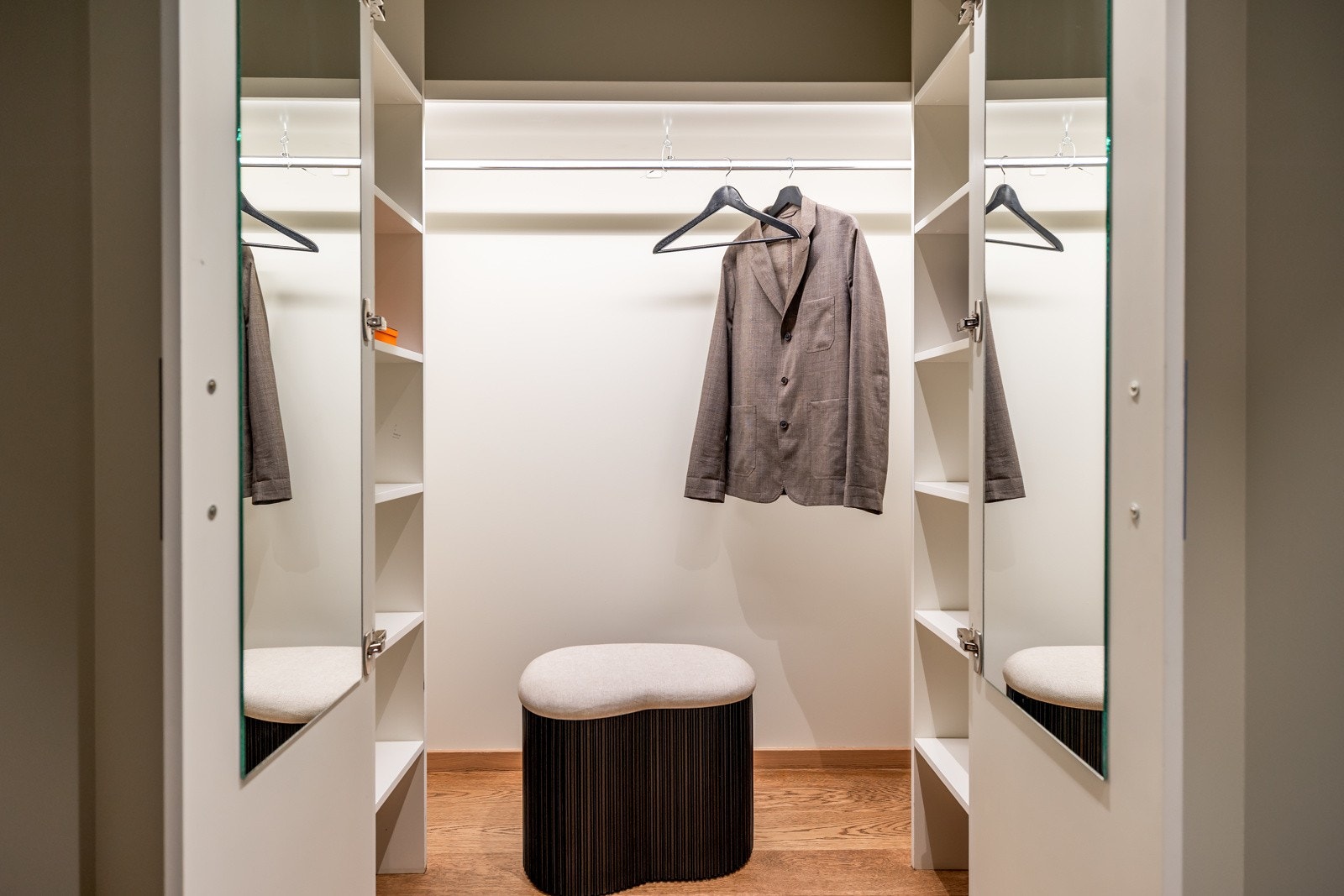 Ytterklær og sko kan henges av i et stilrent garderobeskap med hylleløsning, oppheng og belysning. Galleribilde