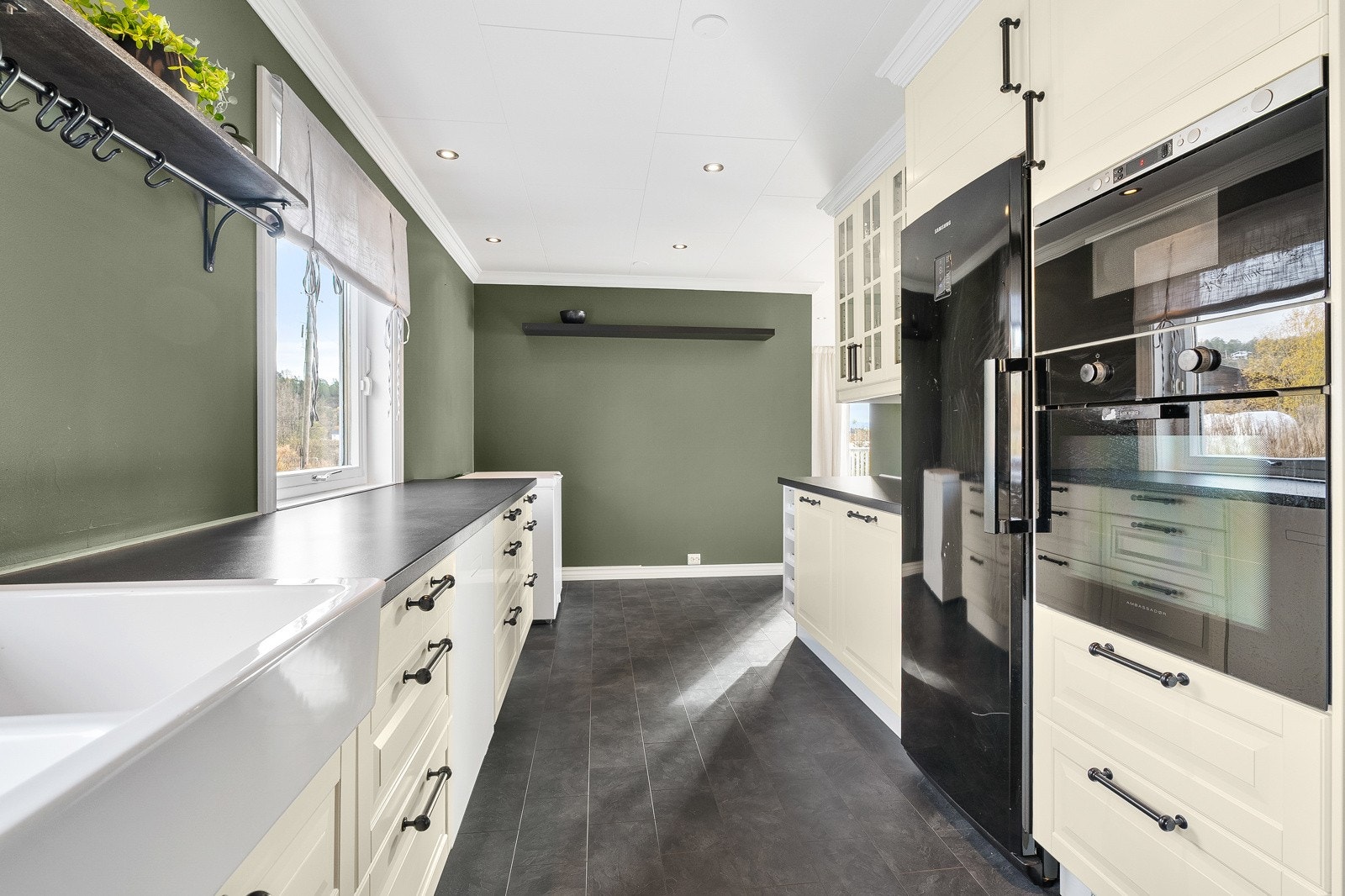 Innbydende kjøkken fra 2013. Store vinduer gir flott lysinnslipp og utsikt til naturen utenfor. Galleribilde