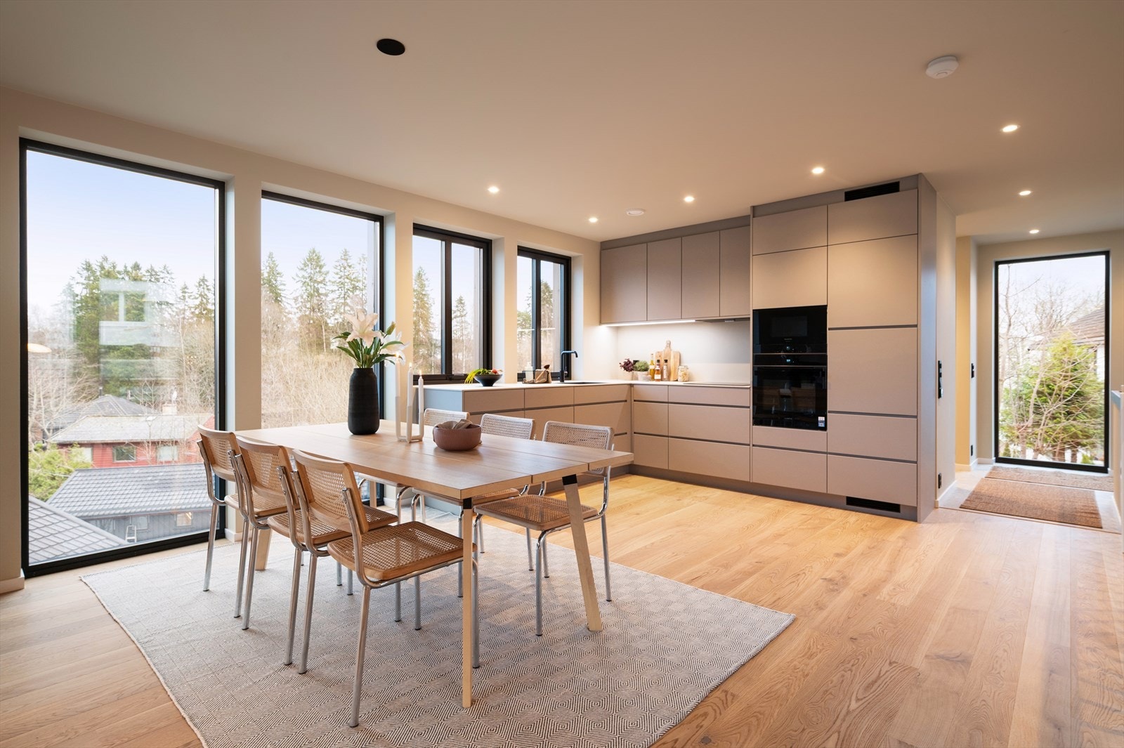 Et moderne og stilrent kjøkken fra Kvik, modell Mano i fargen Arizona Beige. Hyggelig spiseplass med vidt utsyn over nabolaget og åsene rundt. Galleribilde