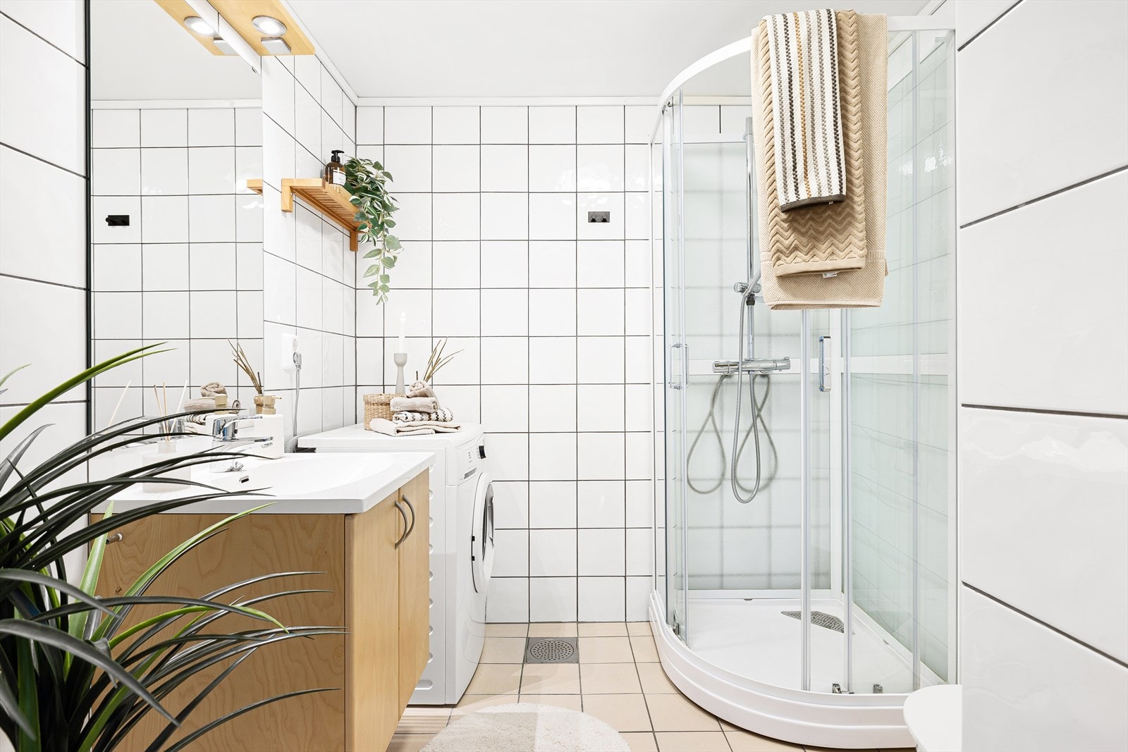 Her har man et flott og funksjonelt baderom på 4 m², flislagt fra topp til tå med varme i gulv for ekstra komfort. Baderommet har praktiske hyller og skap for lagring av baderomsartikler og håndduker. Galleribilde