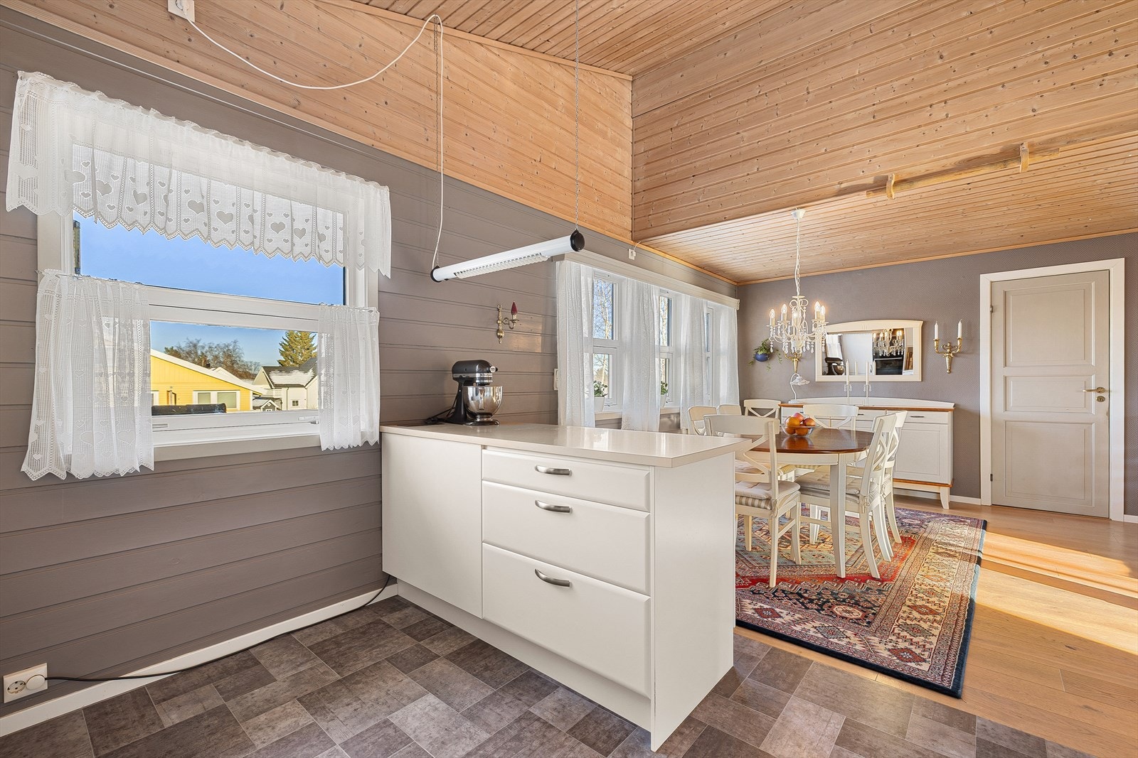 Løsningen med kjøkkenøy gir rikelig benkeplass, noe som gjør kjøkkenet mer funksjonelt og brukervennlig i det daglige. Galleribilde