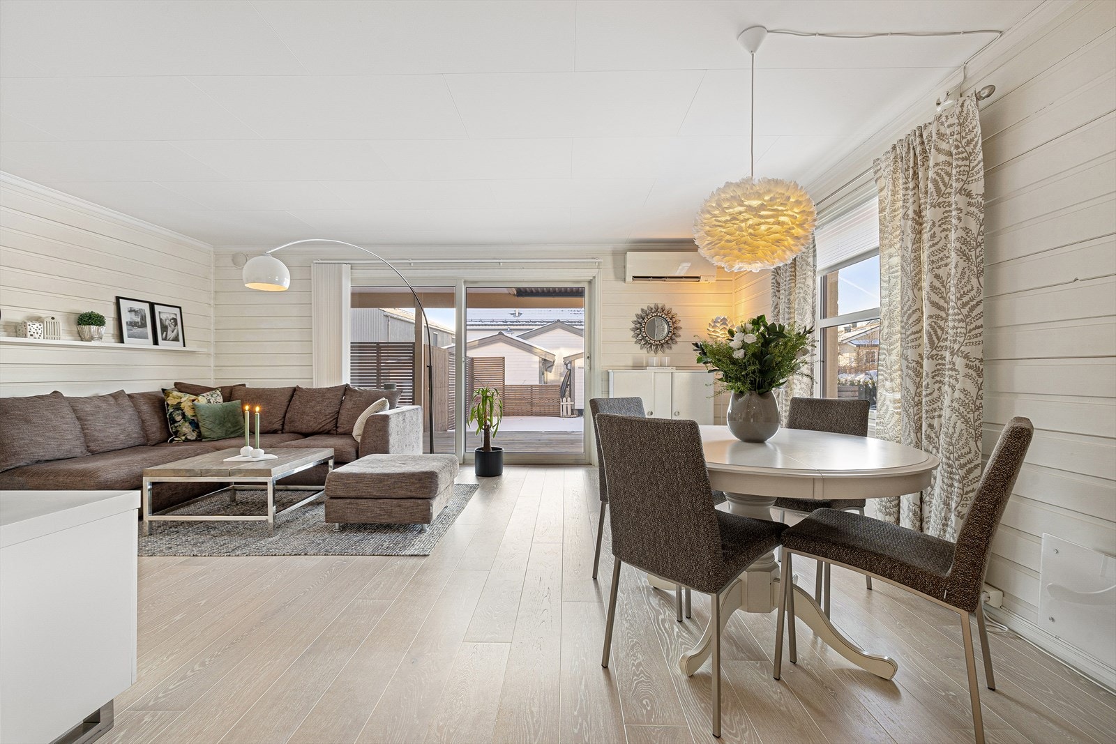 Fra den lyse og innbydende stuen har du direkte tilgang til en stor terrasse på 23 m², perfekt for avslapning og sosiale sammenkomster. Galleribilde