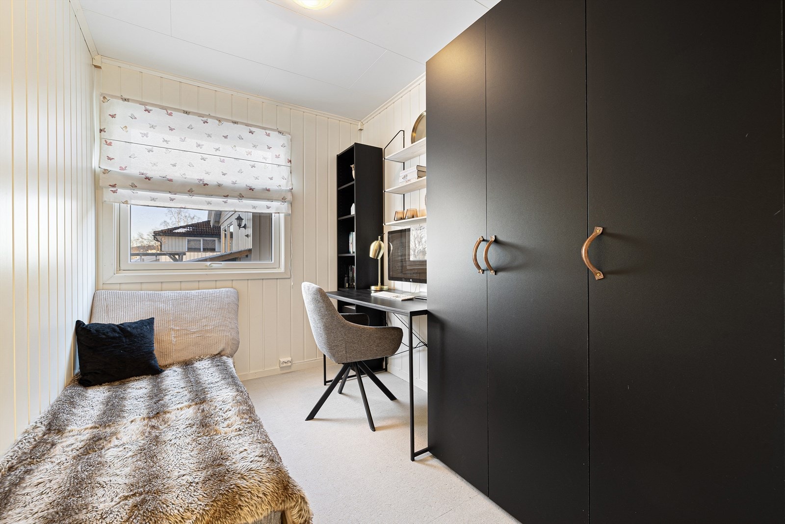 Rommet har gulvteppe og panelplater på vegger, samt takess i himlingen. Her får du et romslig soverom på 6 m² med god skapplass og plass til både seng og skrivepult Galleribilde