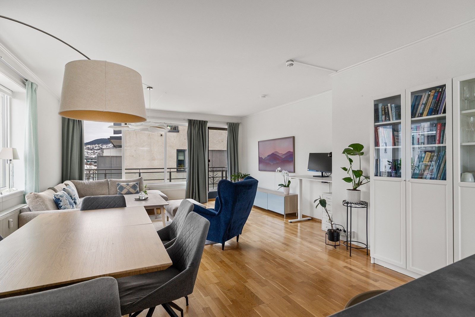 Leilighetens stue er et imponerende rom med gjennomgående lysinnfall fra store vindusflater på tre sider. Galleribilde