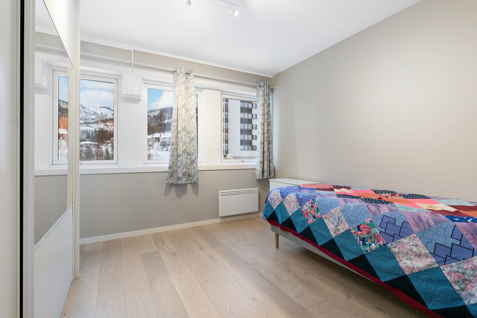 Praktisk soverom med god plass for dobbeltseng, nattbord og annet møblement Galleribilde