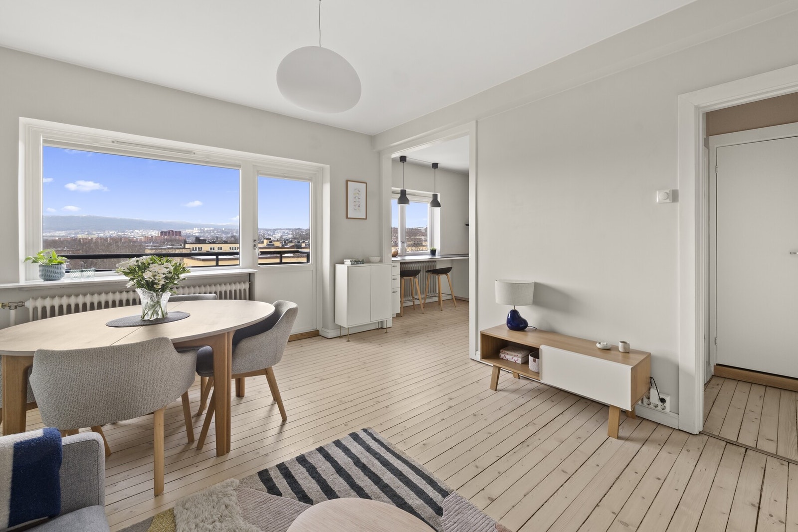 Stuen fremstår som lys og luftig med store vindusflater som gir rikelig med naturlig lys og et vakkert, fritt utsyn Galleribilde