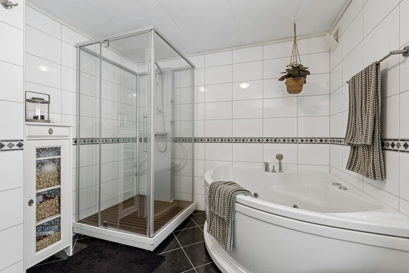 I hovedetasjen er det romslig bad med stort dusjkabinett og boblebadekar. Galleribilde