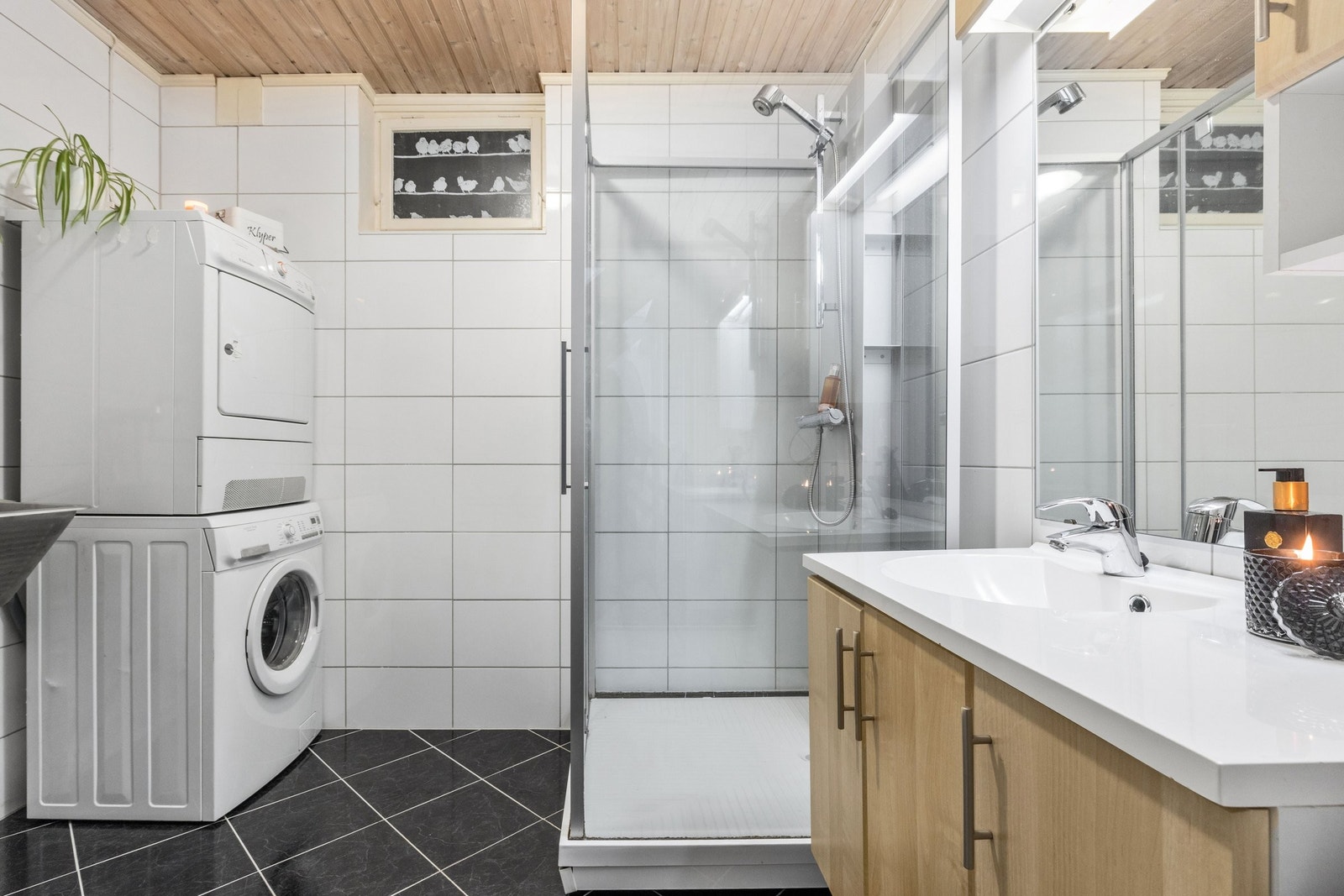 Kombinert bad og vaskerom i underetasje. Rommet har baderomsinnredning med heldekkende servantplate og dusjkabinett, samt utslagsvask og opplegg for vaskemaskin og tørketrommel. Galleribilde