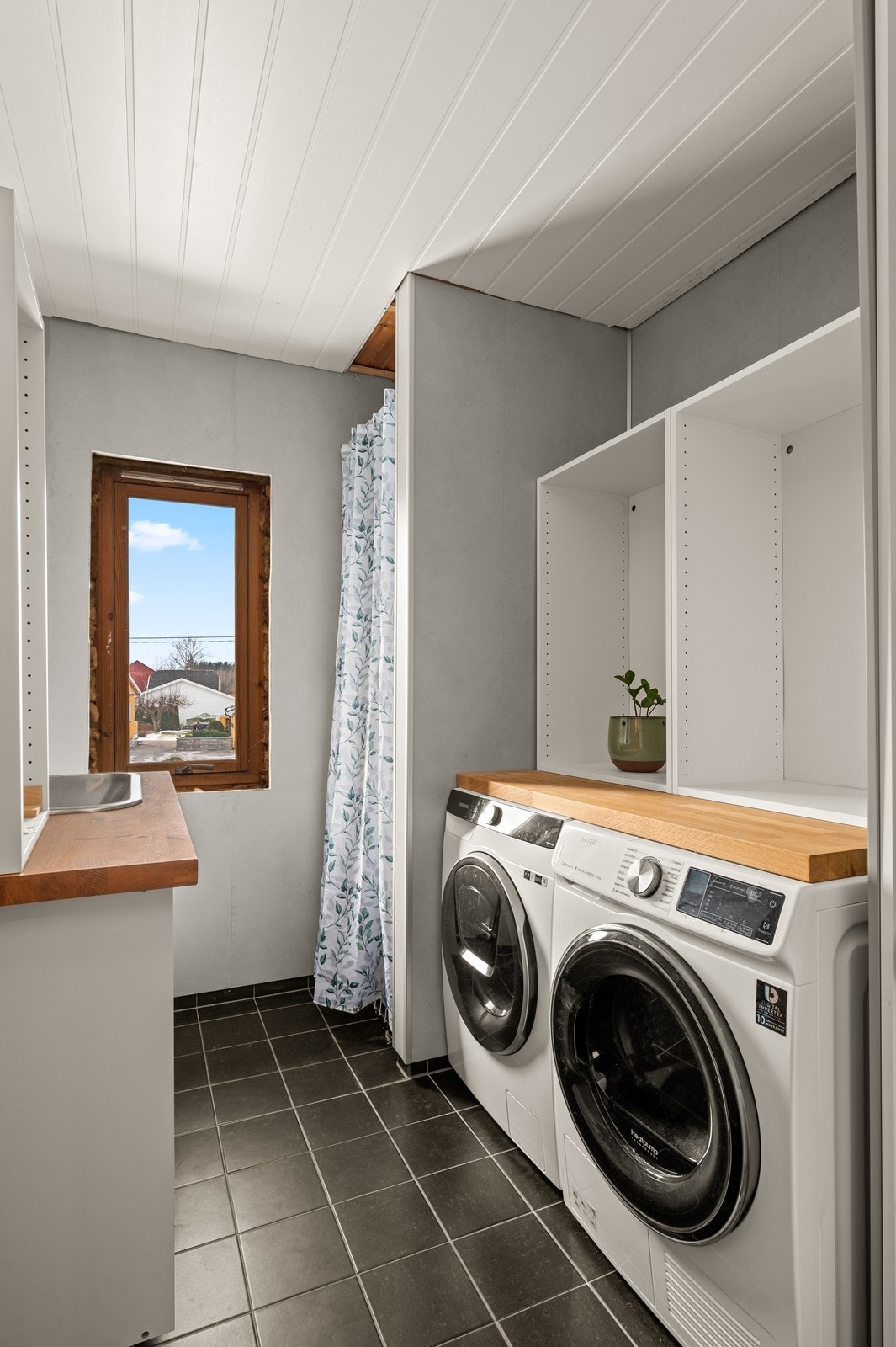 Boligen har et separat og praktisk vaskerom med gode arbeidsflater og opplegg for vaskemaskin. Galleribilde