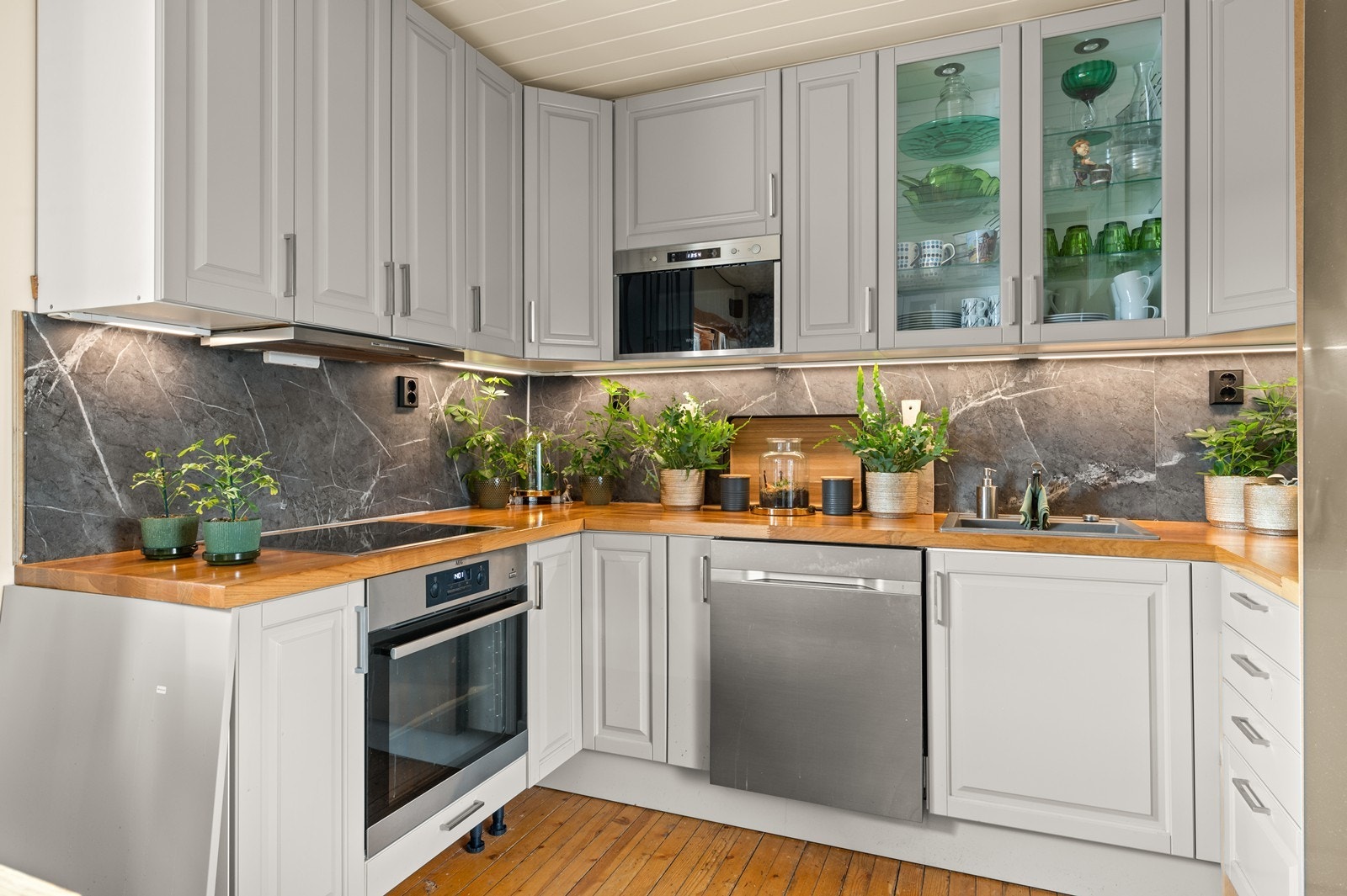 Kjøkkeninnredningen har profilerte fronter, vitrineskap og integrerte hvitevarer. Galleribilde