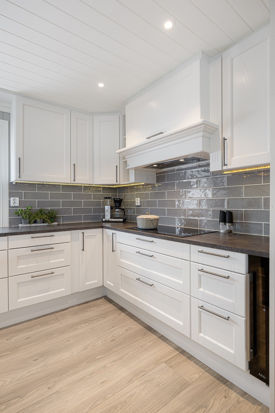 Kjøkkeninnredningen har hvite 1-speils fronter og en slitesterk benkeplate i laminat. Galleribilde