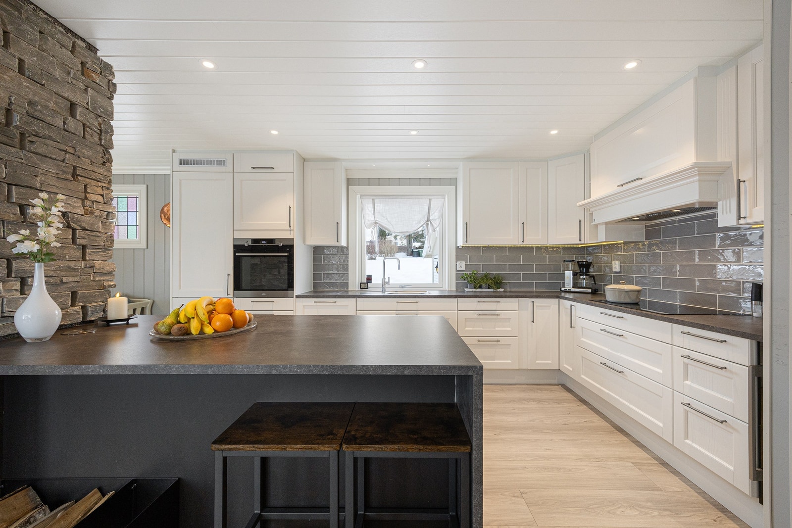 Kjøkkenet fra 2018 har en funksjonell kjøkkenøy med benkeskap og spiseplass. Galleribilde