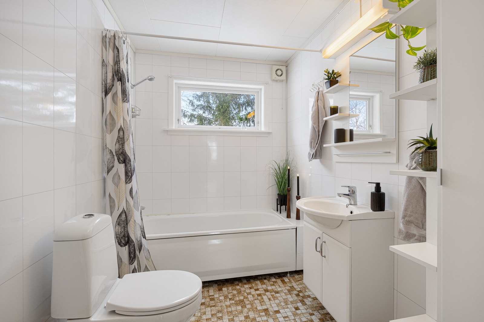 Badet i første etasje har flislagt gulv med elektriske varmekabler og badekar med dusj. Galleribilde