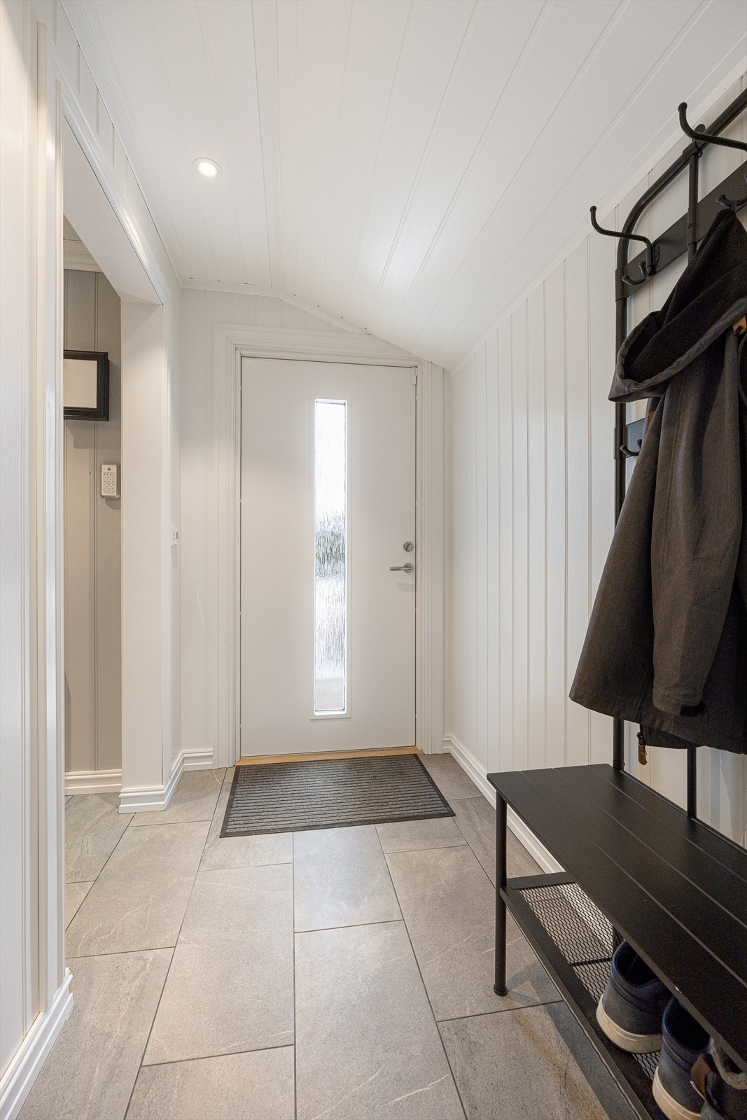 Entréen har flislagt gulv med elektrisk gulvvarme som gir en behagelig velkomst. Galleribilde