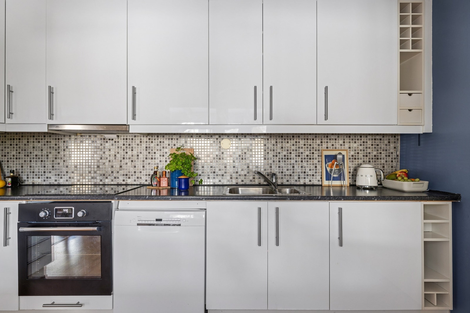 Kjøkkeninnredning med glatte fronter og rikelig med skap- og benkeplass. Galleribilde