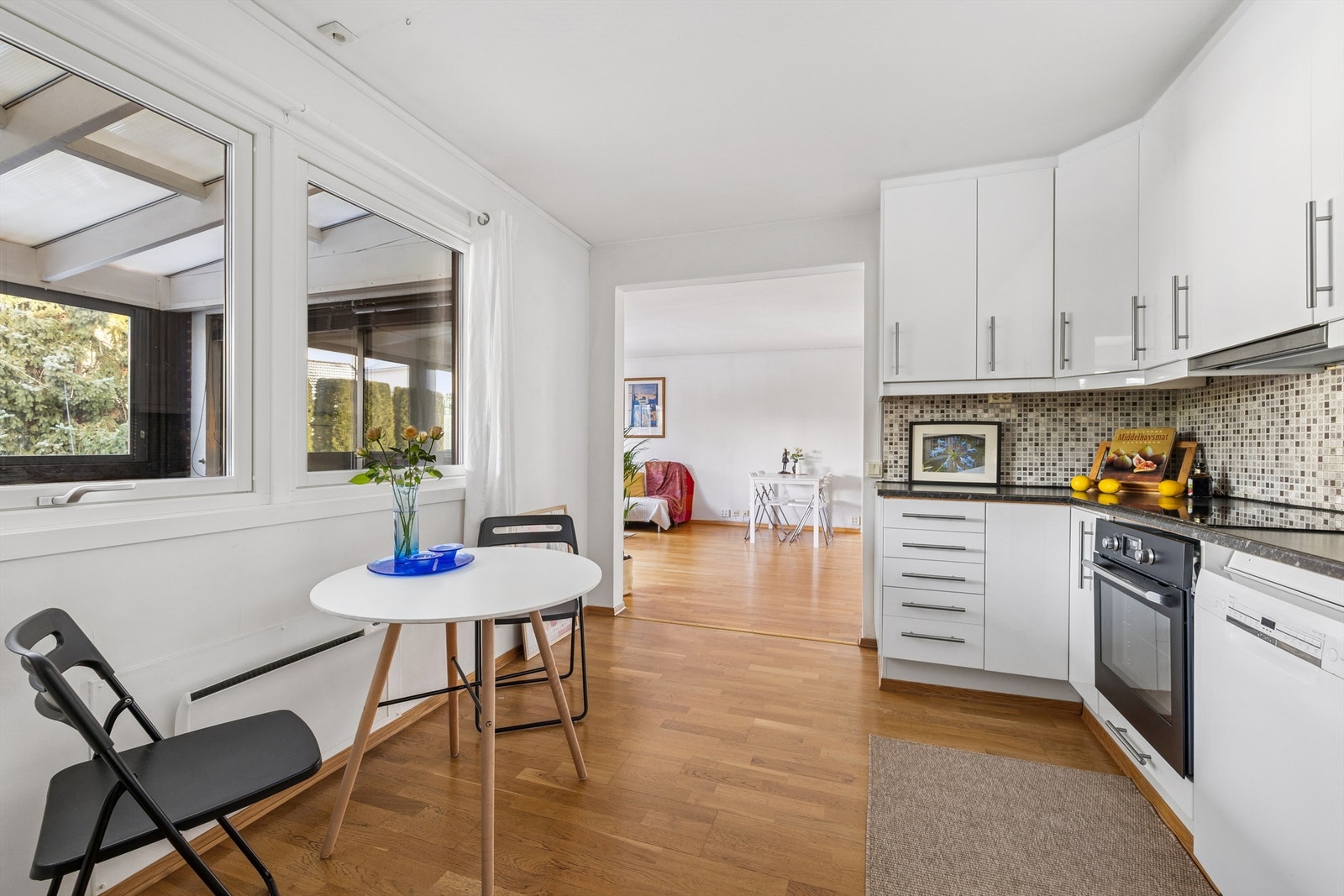 Den delvis åpne løsningen mellom kjøkken og stue skaper en sosial og luftig atmosfære. Galleribilde