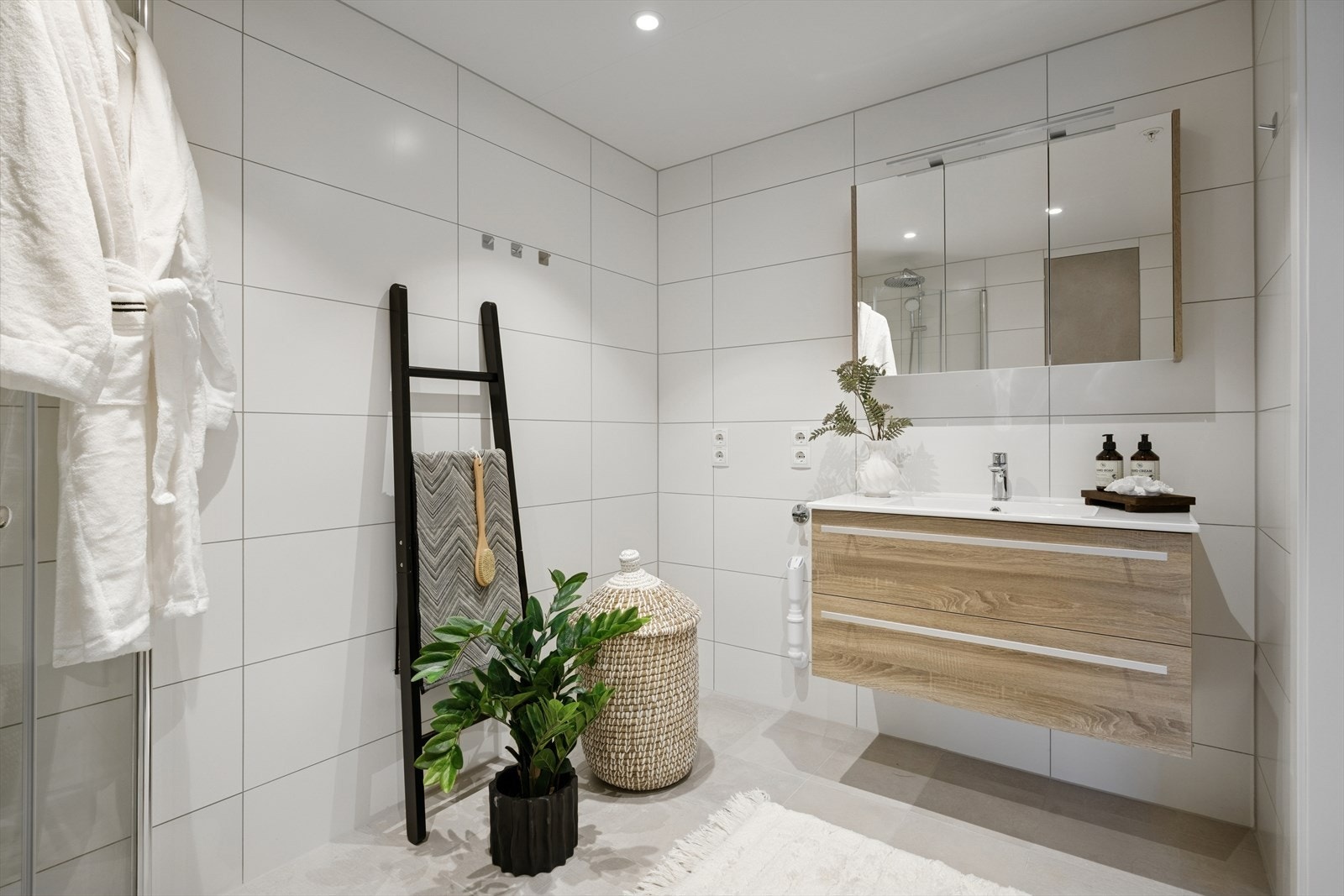 Baderom på 5,3 m² fremstår som moderne og delikat, med fliser på både gulv og vegger som gir rommet et stilrent og tidløst preg. Downlights i tak. Galleribilde