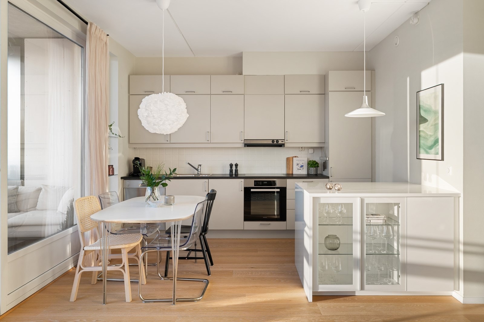 Kjøkkenet, oppusset med spraylakkerte fronter i 2023, kombinerer stilrent design med smarte løsninger og rikelig med oppbevaringsplass. Galleribilde