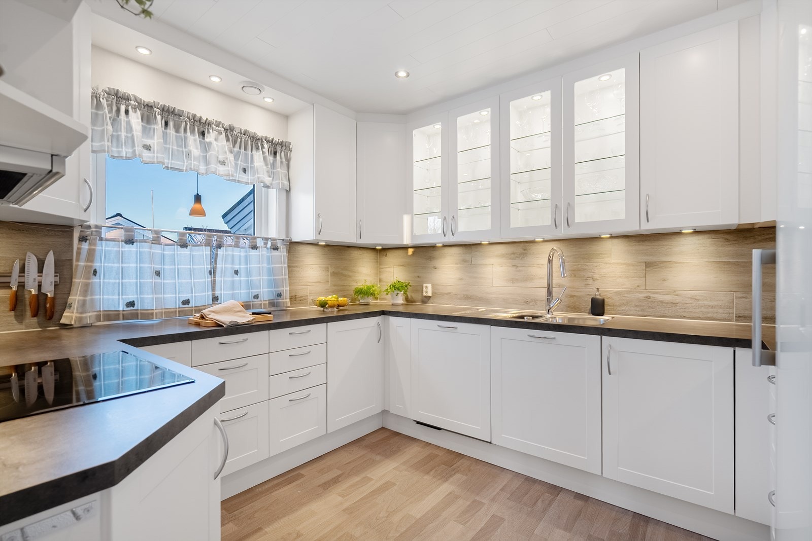 Lyst og fint kjøkken med masse skap og benkeplass Galleribilde