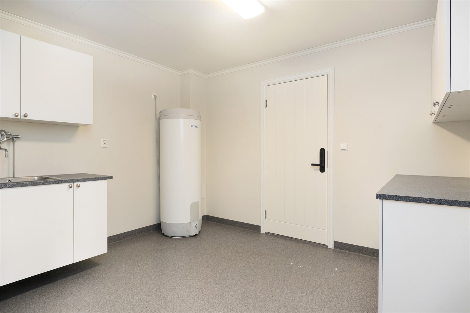 Praktisk og romsleg vaskerom med direkte utgang til garasje. Vaskerommet har godt med skåpplass og gode tørkemogelegheiter. Galleribilde