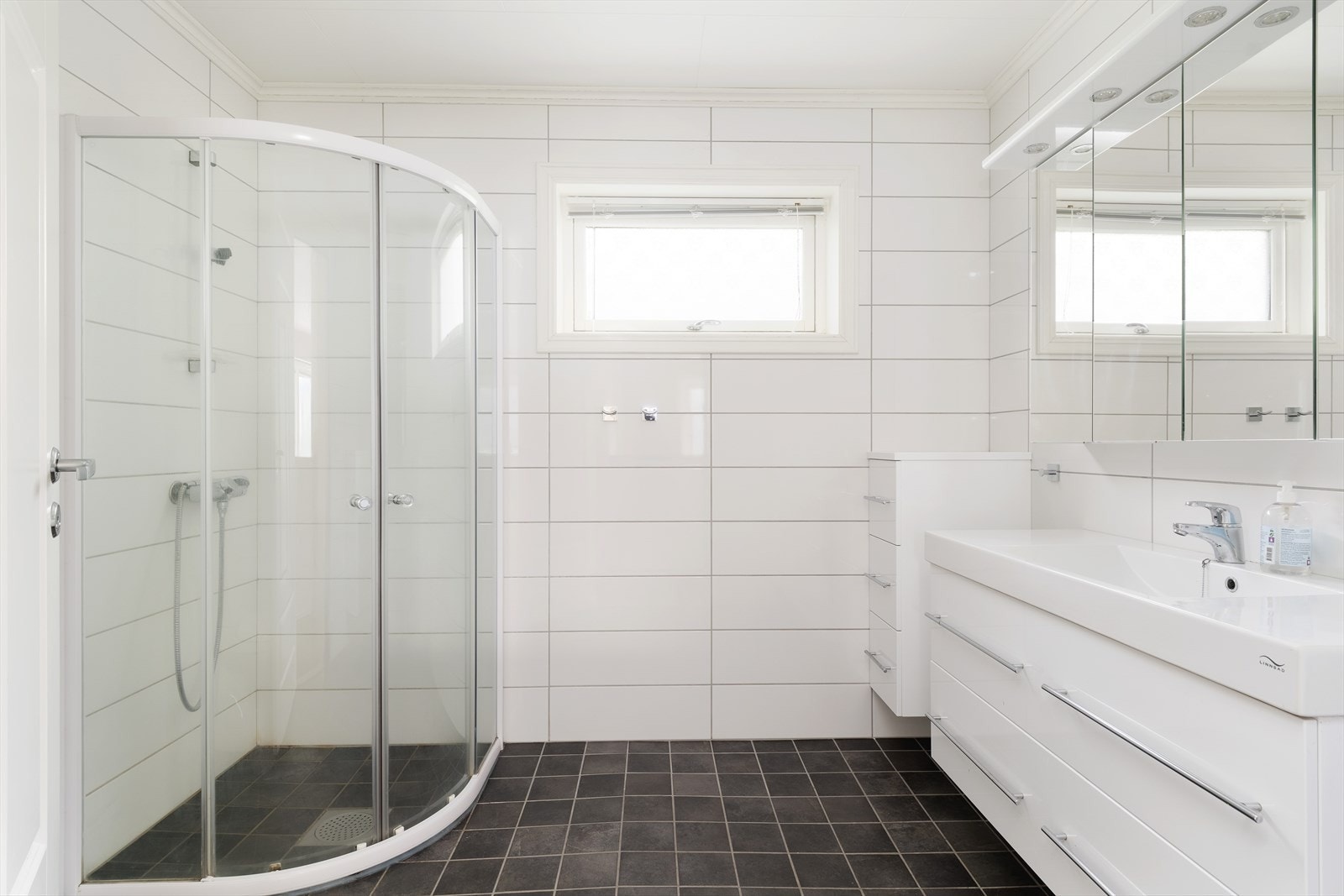 Tidlaust heilflisa bad i hovudetasjen, innreia med skuffeseksjon, dusjhjørne og toalett. Galleribilde