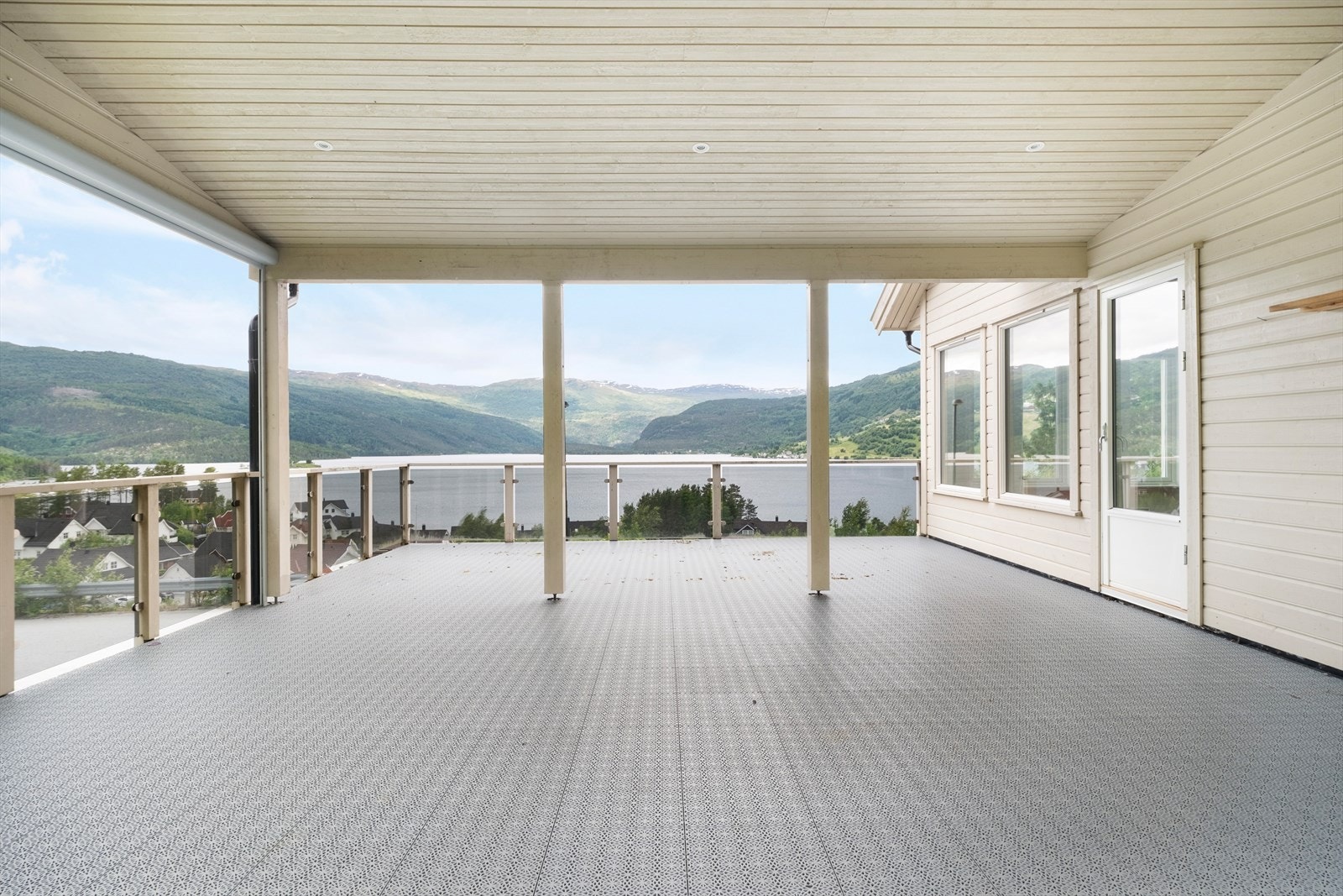 Frå stova er det utgang til ein stor og delvis overbygd altan - eit flott uterom og boltreplass uansett vær og årstid. Galleribilde