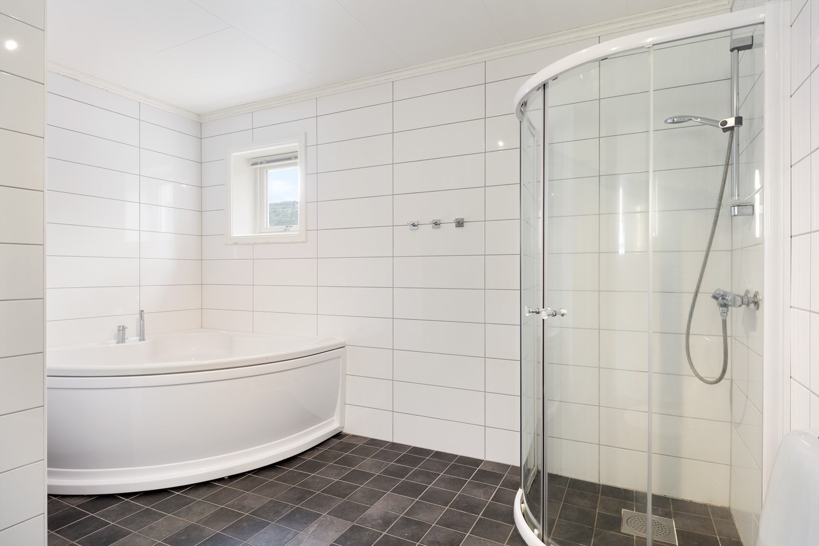 Badet er innreia med servant, toalett, dusj og hjørnebadekar. Galleribilde