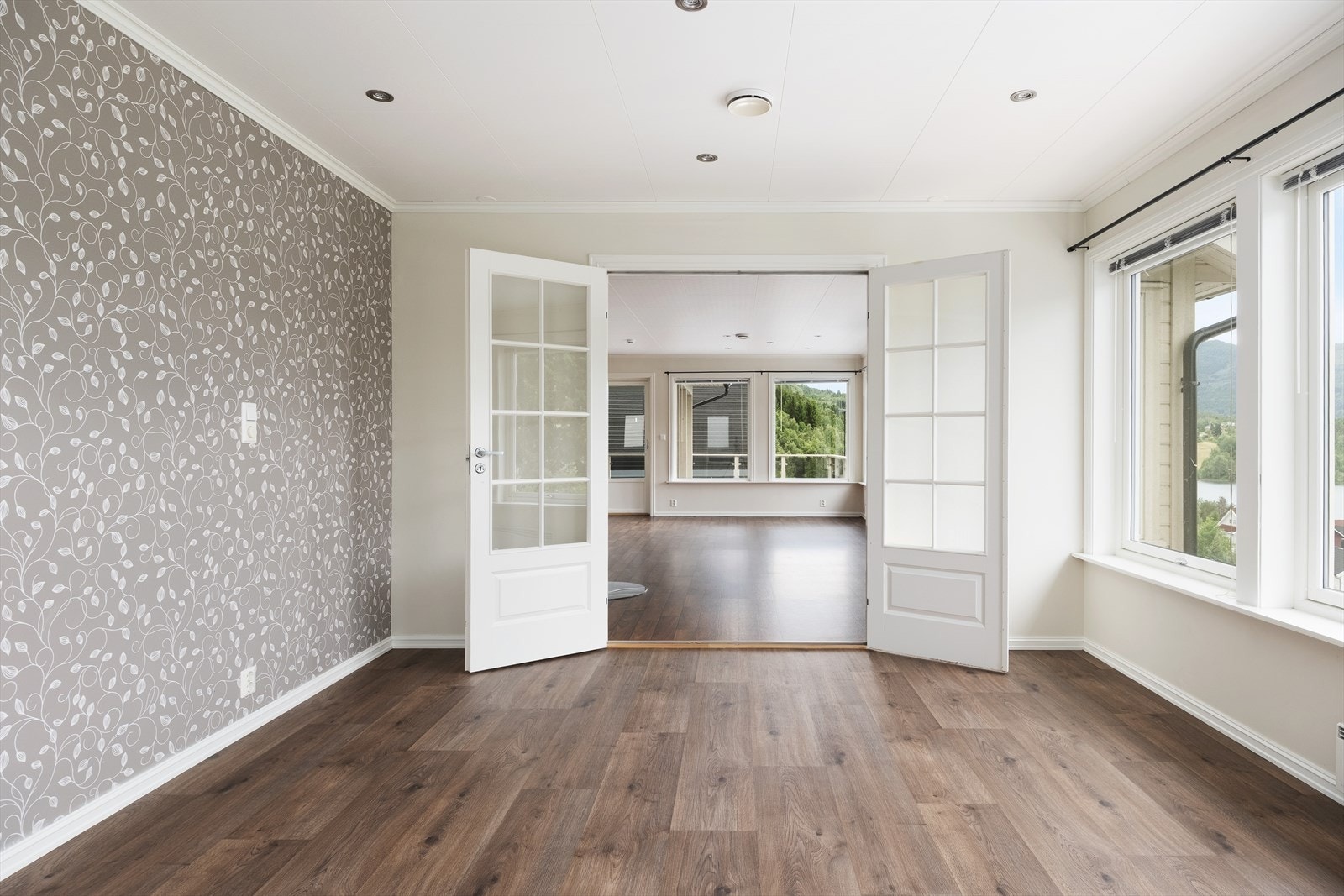 Som ein naturleg forlenging av hovudstova kjem ein inn i eit lyst og innbydande ekstra opphaldsrom adskilt med doble glasdører. Galleribilde