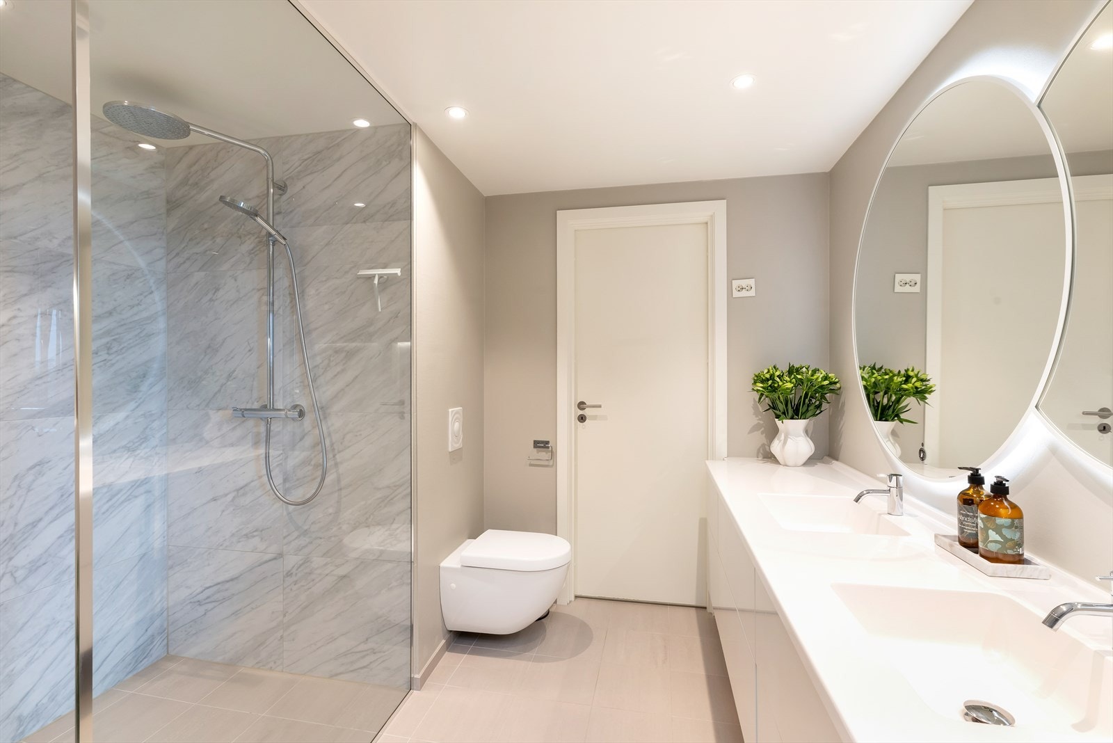 Badet er innredet med dobbelservant, vegghengt toalett og en meget romslig dusj Galleribilde