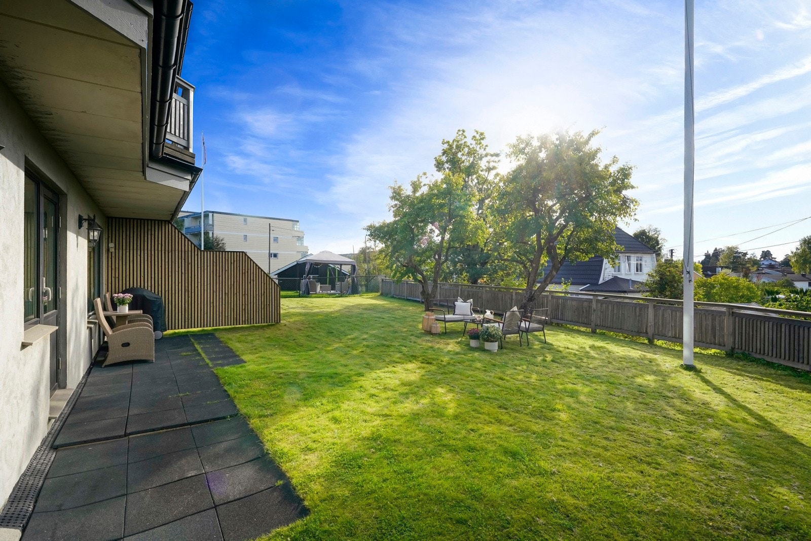 Stor opparbeidet tomt med sittegrupper, plen og prydbusker Galleribilde