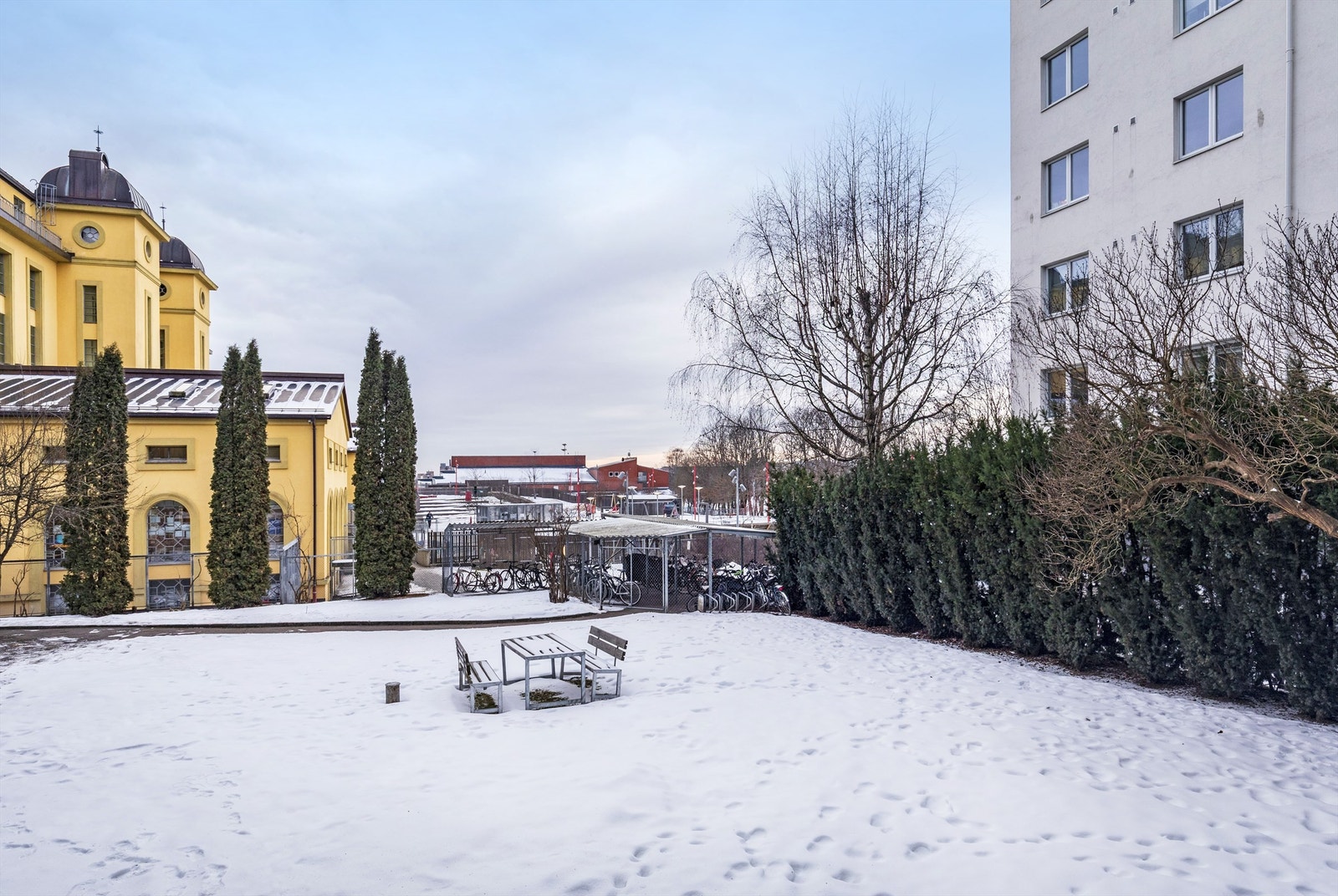 Rolig og hyggelig bakgård med plen og sittegruppe samt inngjerdet sykkelparking under tak. Galleribilde