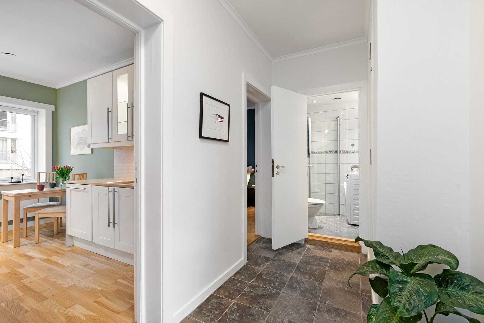 Entréen er plassert i midten av leiligheten og har adkomst til alle rommene. Til høyre for baderommet er det et innbygget skap med plass til sko, jakker og støvsuger. Galleribilde